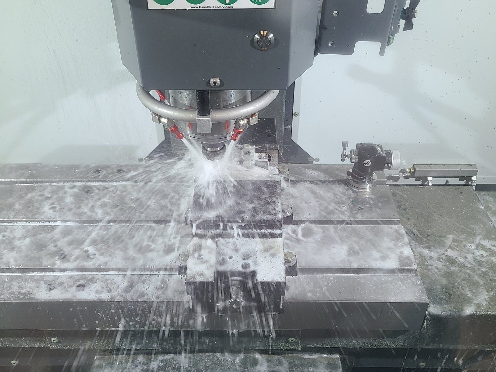 Mill cutting a bar held in the vise, coolant and chips flying